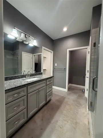 a bathroom with a granite countertop sink mirror and shower