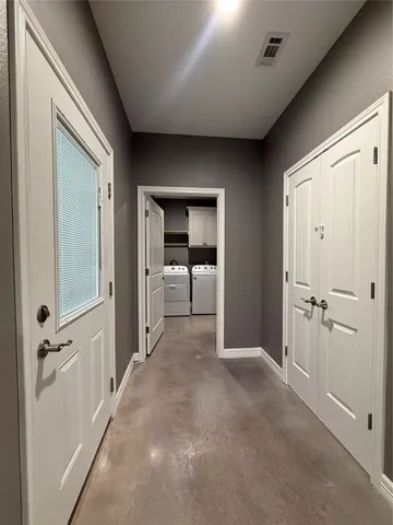 a view of a hallway with closet and wooden shelves