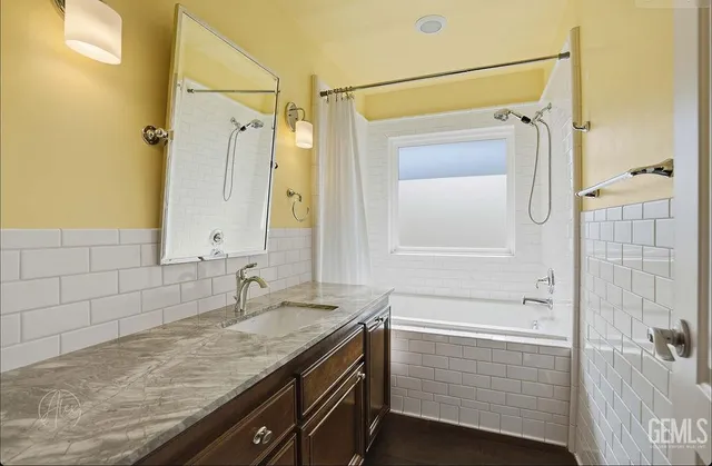 a bathroom with a granite countertop sink a mirror and shower