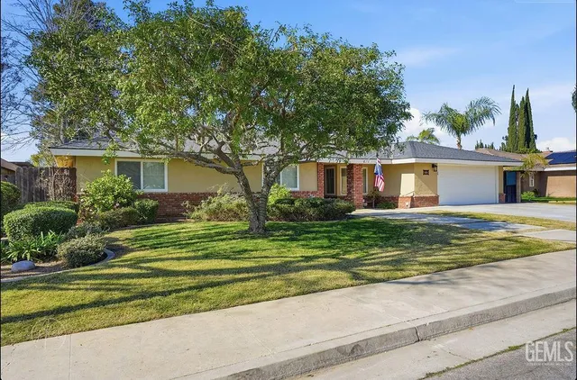a front view of a house with a yard and potted plants