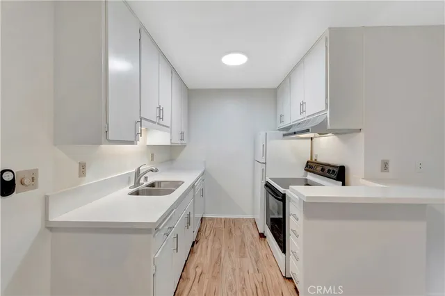 a kitchen with a sink a stove and cabinets