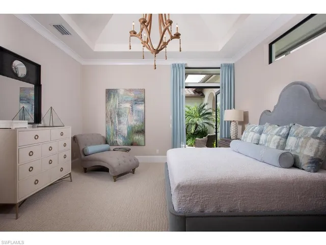 a bedroom with a bed and large windows