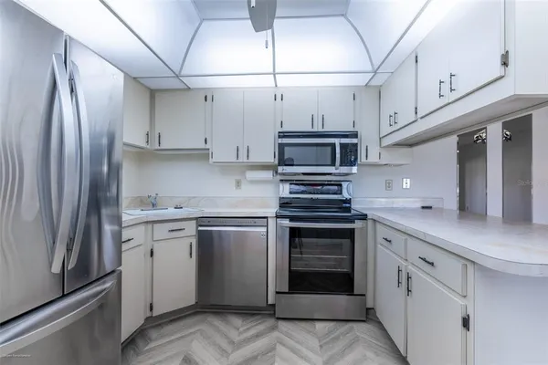a kitchen with stainless steel appliances a sink cabinets and a refrigerator