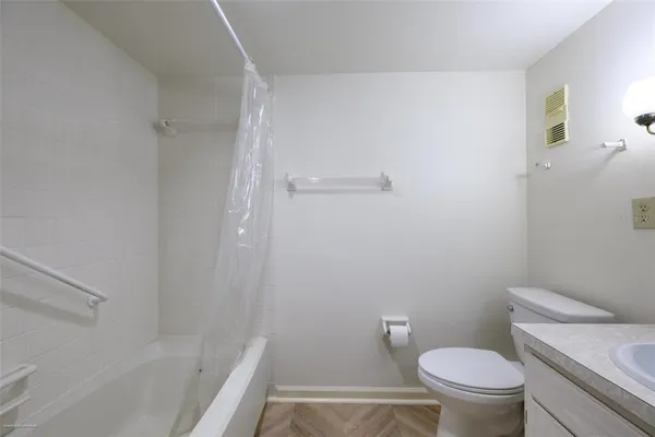 a white toilet sitting next to a bath tub