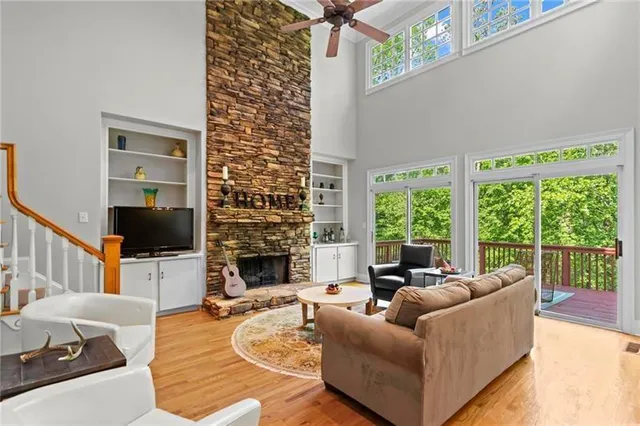 a living room with fireplace furniture and a large window