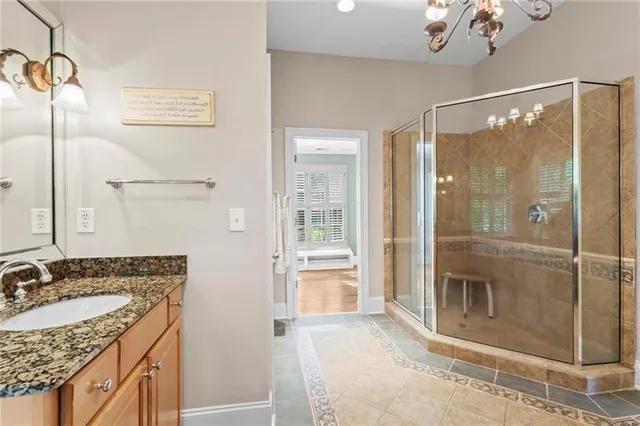 a bathroom with a granite countertop sink a mirror and shower