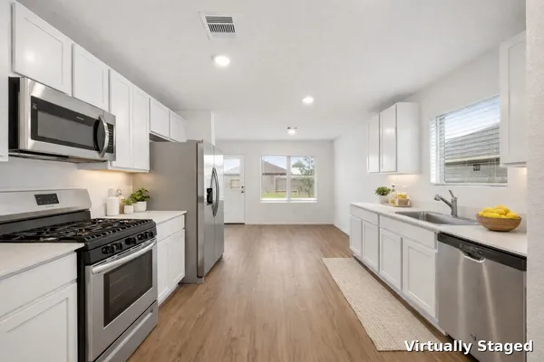 a view of empty room with wooden floor and windows
