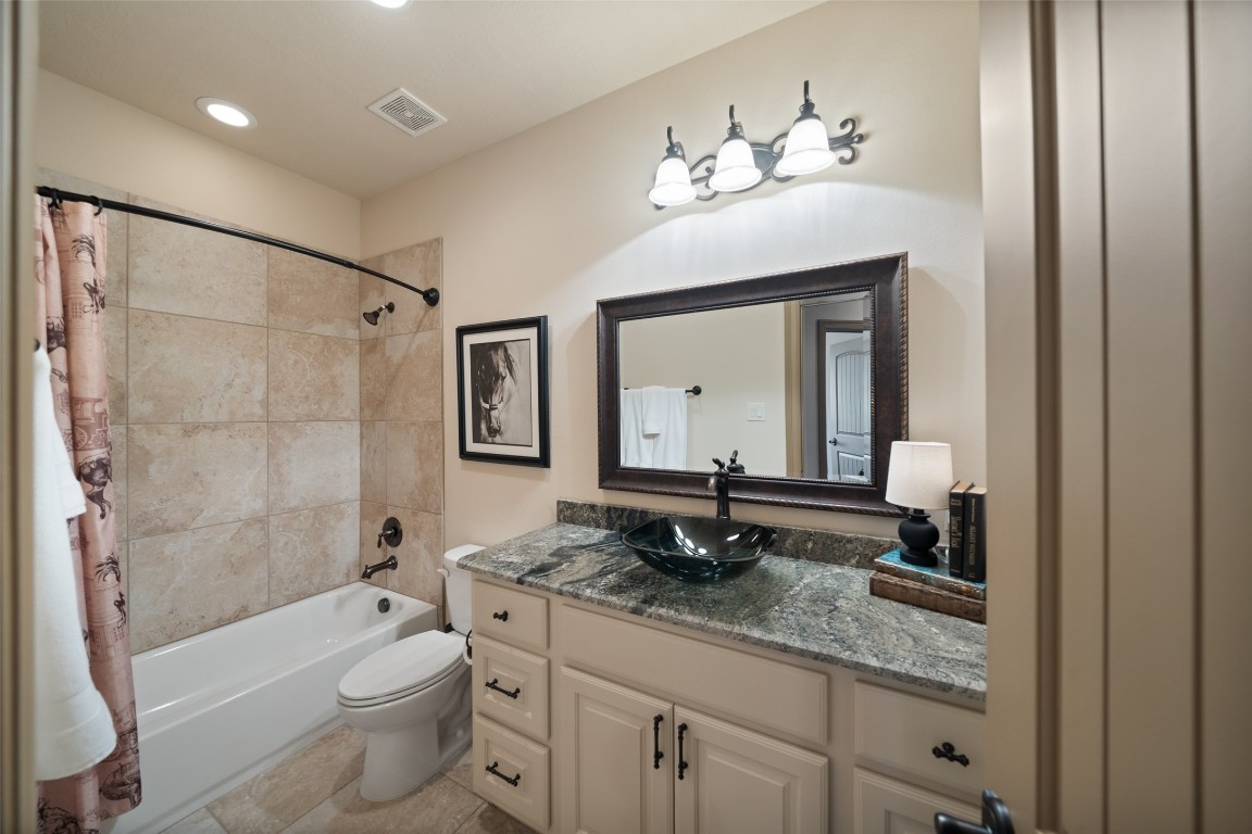 40 Stewart Road New Waverly, TX 77358 - Photo 24 of 50 a bathroom with a granite countertop sink a toilet a mirror a bathtub and shower