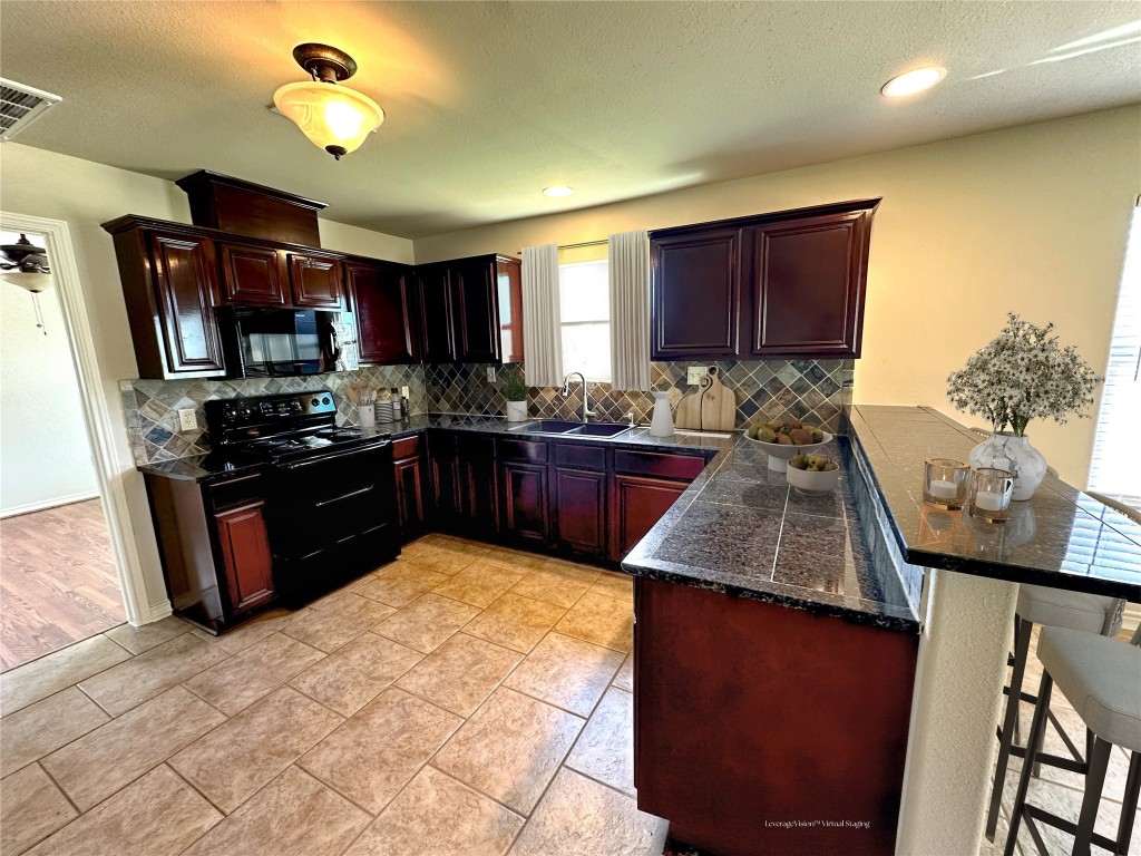 40 Stewart Road New Waverly, TX 77358 - Photo 33 of 50 a kitchen with stainless steel appliances granite countertop a sink counter space cabinets a stove and a window