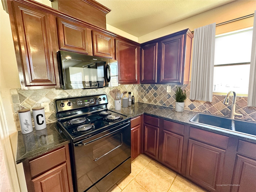 40 Stewart Road New Waverly, TX 77358 - Photo 34 of 50 a kitchen with stainless steel appliances granite countertop a stove a sink and a microwave