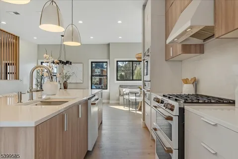 a kitchen with stainless steel appliances a sink stove and cabinets