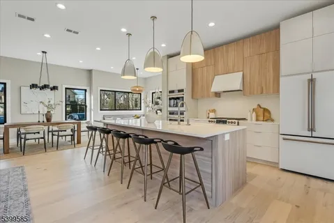 a kitchen with stainless steel appliances kitchen island granite countertop a stove a sink a oven a dining table and chairs