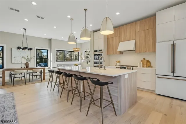 a kitchen with stainless steel appliances kitchen island granite countertop a stove a sink a oven a dining table and chairs