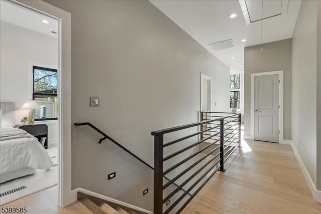 a view of a hallway with bedroom and wooden floor