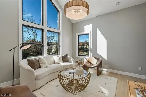 a living room with furniture a table and a large window