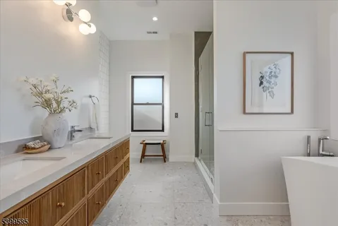 a bathroom with a double vanity sink a mirror and a bathtub