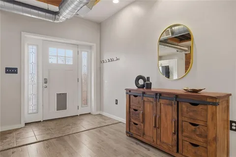 a view of a livingroom with wooden floor and a mirror