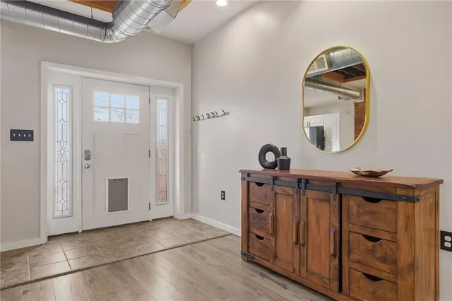 a view of a livingroom with wooden floor and a mirror