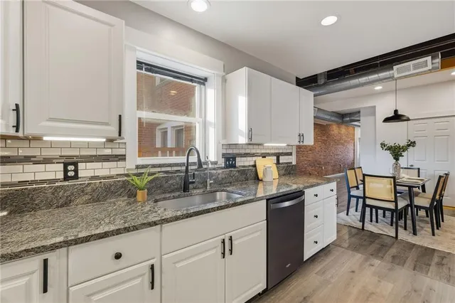 a kitchen with granite countertop a sink and cabinets