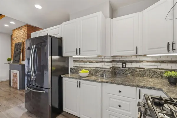 a kitchen with stainless steel appliances granite countertop a refrigerator and a sink
