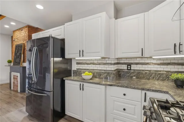 a kitchen with stainless steel appliances granite countertop a refrigerator and a sink