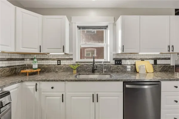 a kitchen with stainless steel appliances granite countertop a sink a stove and cabinets