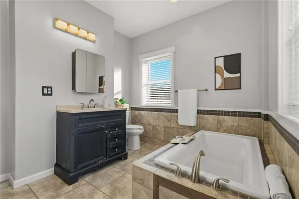 a bathroom with a tub sink and mirror