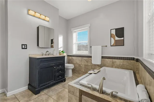 a bathroom with a tub sink and mirror