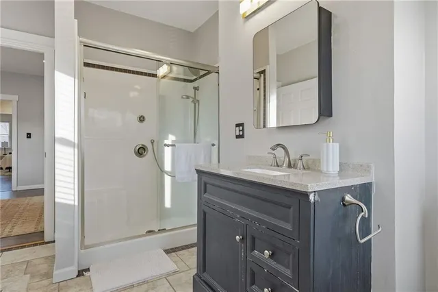a bathroom with a shower sink and mirror