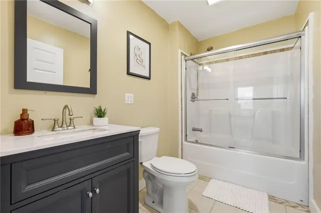 a bathroom with a granite countertop sink mirror vanity and toilet