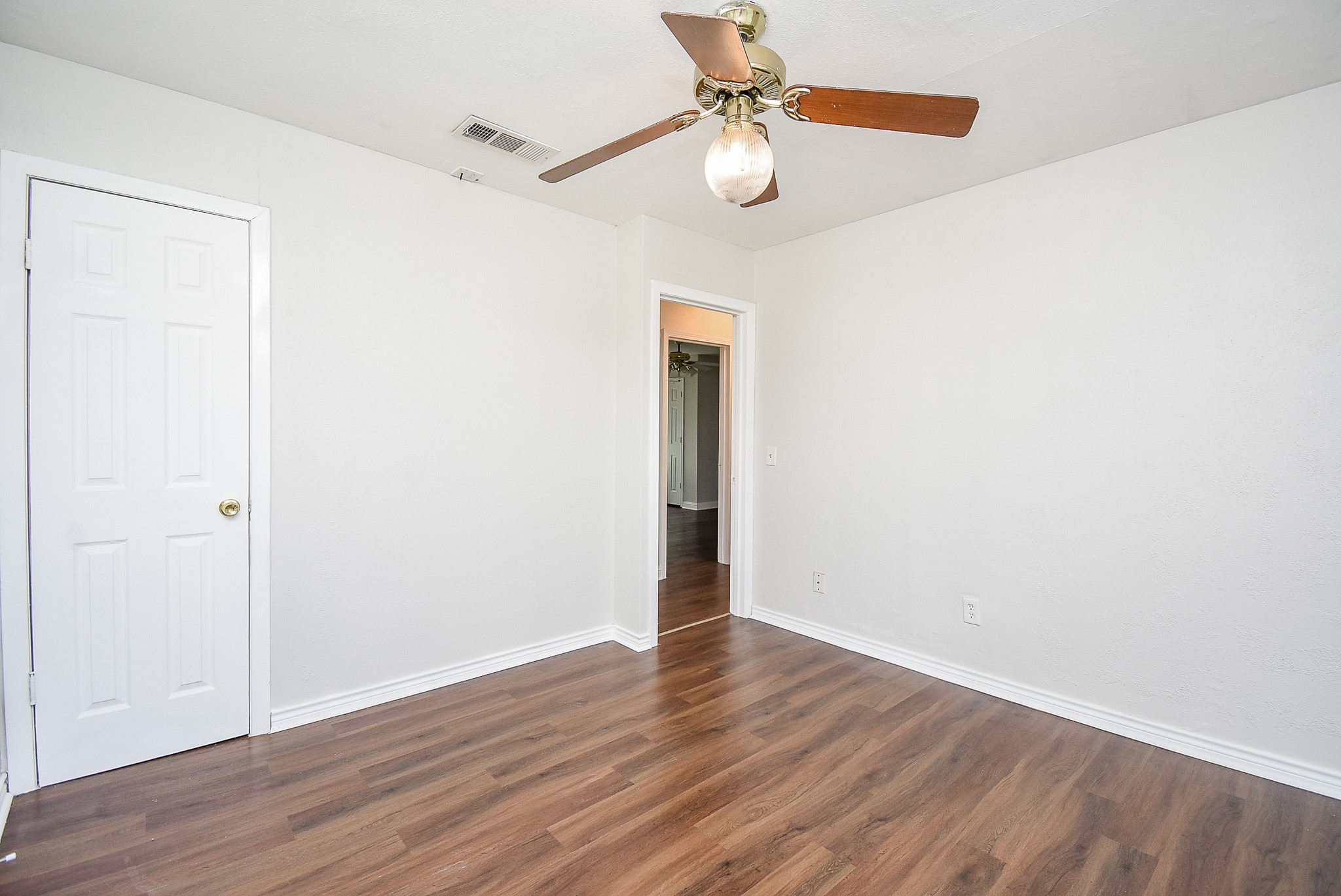 14235 Buffalo Street Needville, TX 77461 - Photo 14 of 21 an empty room with wooden floor fan and windows