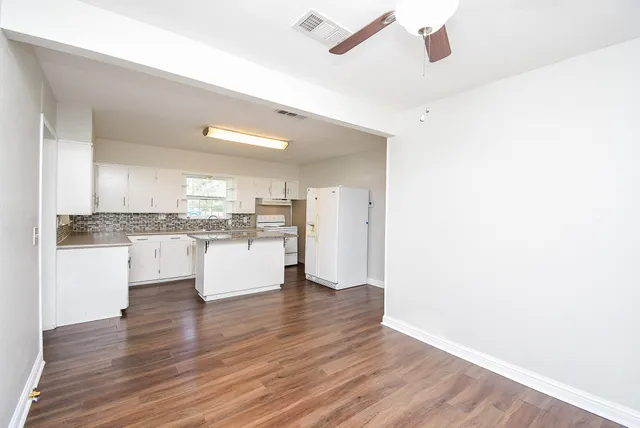 a kitchen with a refrigerator and white cabinets