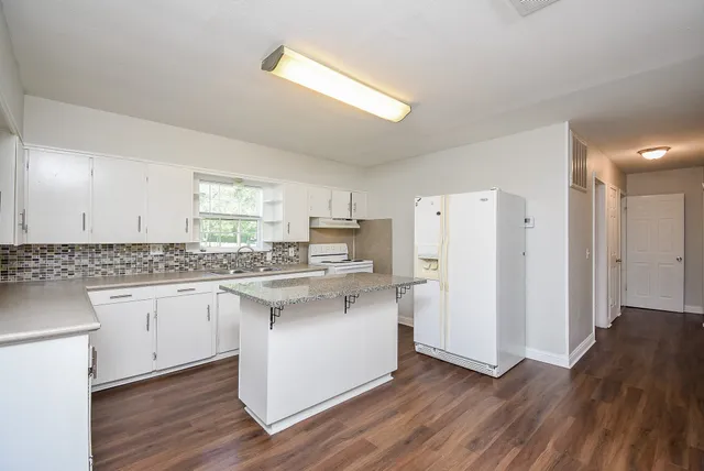 a kitchen with white cabinets and white appliances