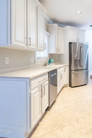 a kitchen with stainless steel appliances granite countertop grey cabinets a stove a sink and dishwasher
