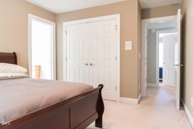 a bed sitting in a bedroom next to a window