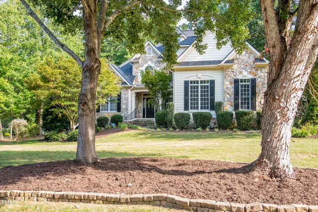 a view of a house with garden and trees