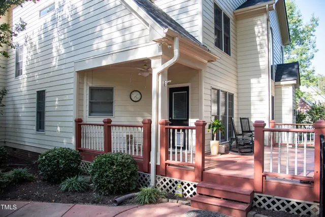 a front view of a house with a yard and large trees