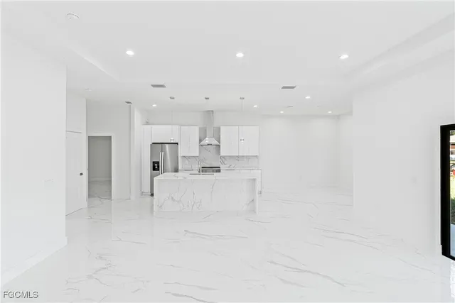 a view of kitchen with white cabinets and stainless steel appliances