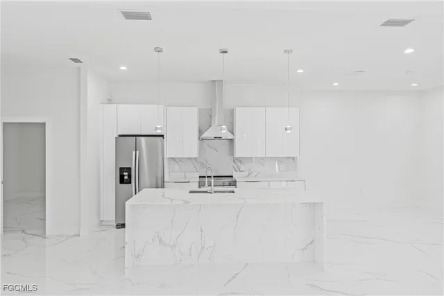 a kitchen with kitchen island cabinets and refrigerator