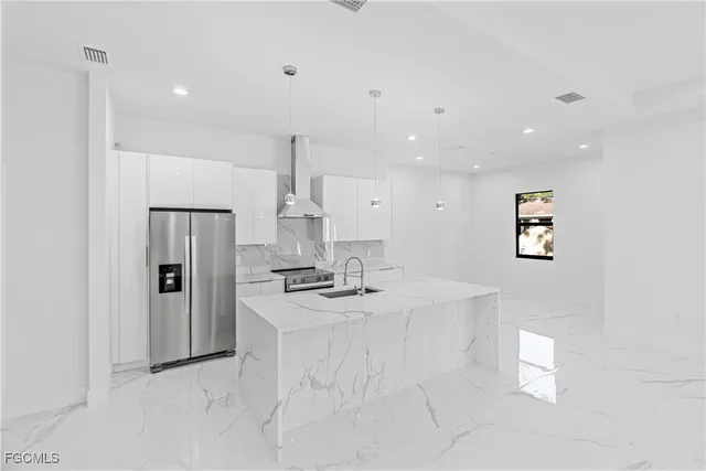 a view of kitchen with refrigerator stove and wooden floor