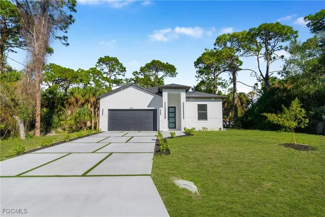 a front view of a house with a garden and yard