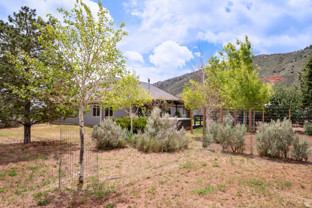 7343 North Sawtooth Cv Road Vernal, UT 84078 - Photo 49 of 64 Expansive backyard space featuring a gray exterior residence with multiple windows and a covered patio area