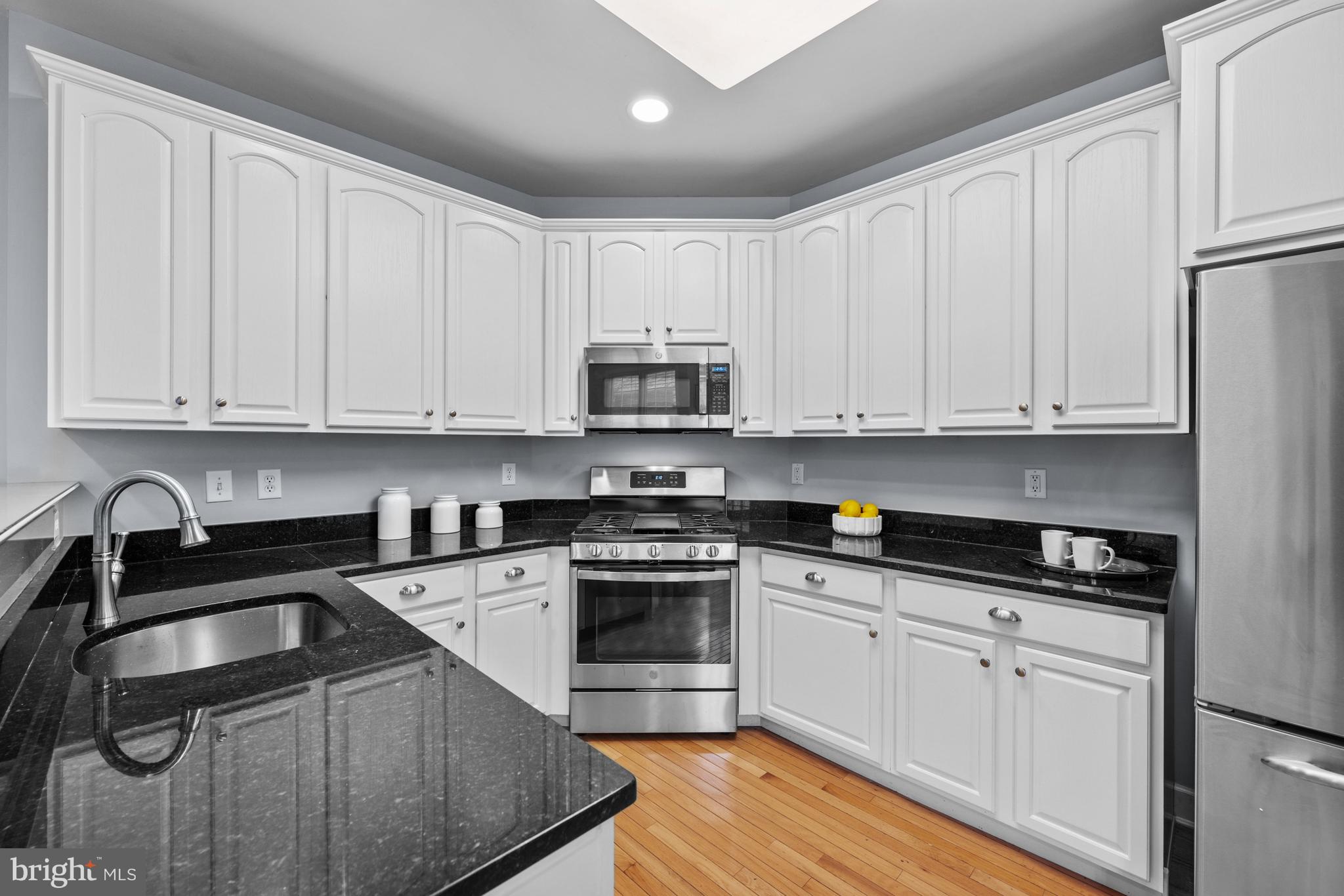 313 Hart Road Gaithersburg, MD 20878 - Photo 13 of 33 a kitchen with granite countertop white cabinets and stainless steel appliances
