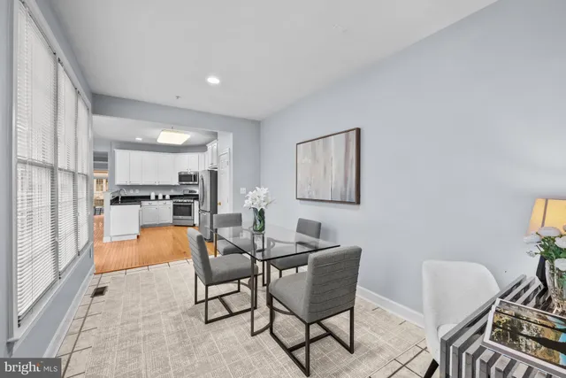 a dining room with furniture and a kitchen view