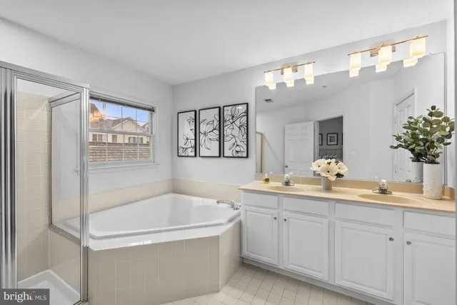 a bathroom with a tub a sink and mirror