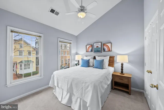 a bedroom with a bed and a lamp on dresser