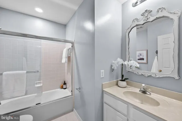 a bathroom with a tub sink and mirror