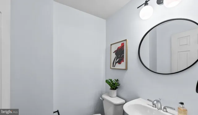 a bathroom with a toilet a sink and mirror