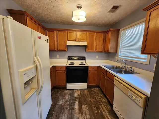 a kitchen with a sink a refrigerator and a stove