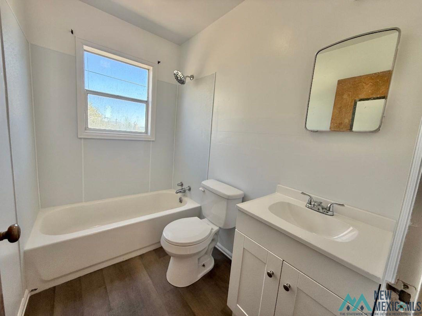533 South 2nd Street Raton, NM 87740 - Photo 32 of 43 Bathroom featuring a white vanity with integrated sink, chrome faucet, and wood-finish flooring